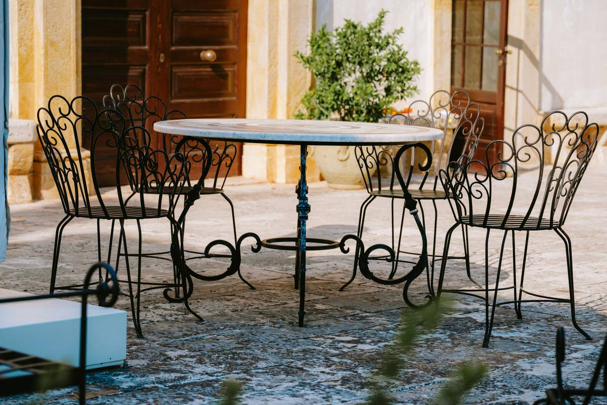 A sturdy tilt-adjustable beach umbrella providing shade over a patio furniture set, part of outdoors patio furniture patio umbrellas collection