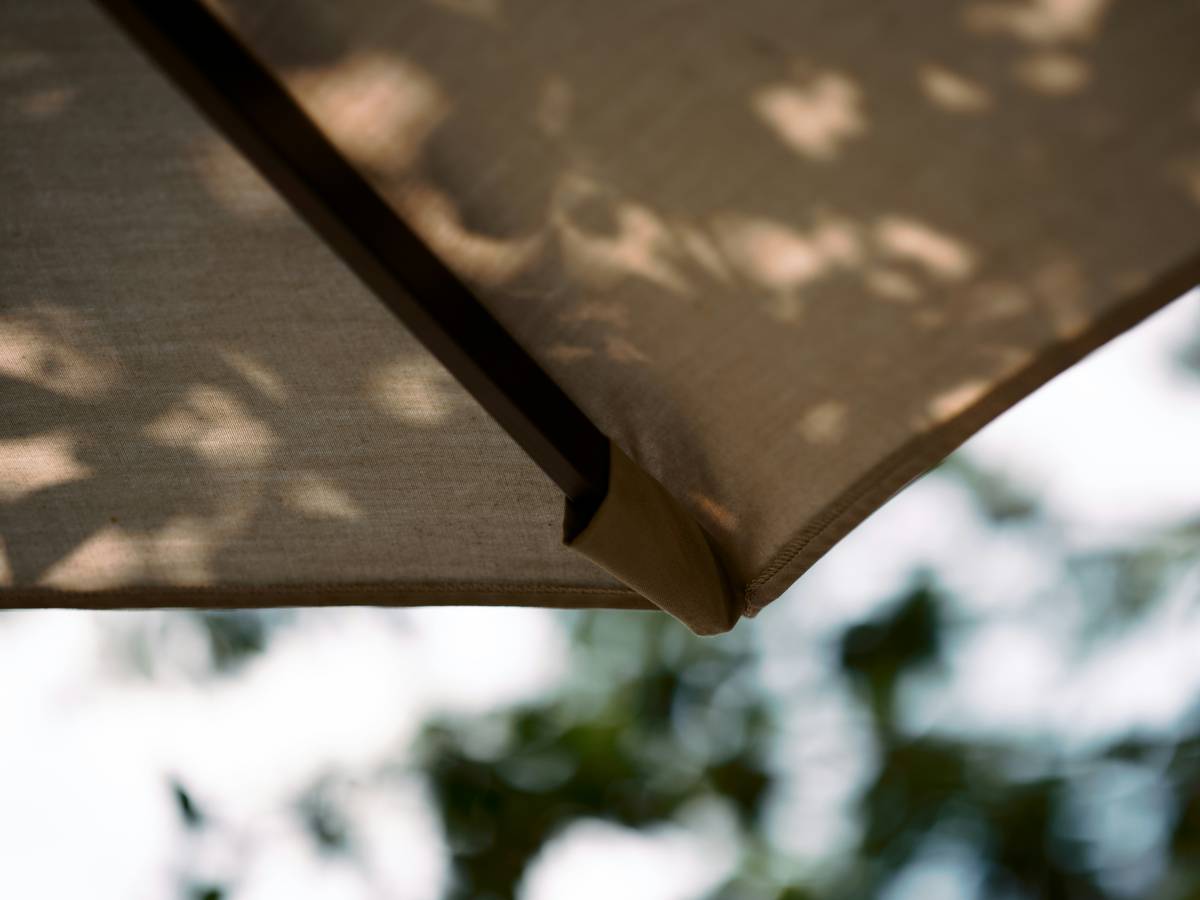exterior shades for patio umbrella providing UV protection over a coastal deck with lounge chairs