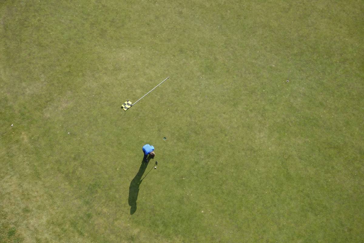 Close-up of a golf umbrella windproof and rainproof model withstanding strong coastal winds on a sandy beach