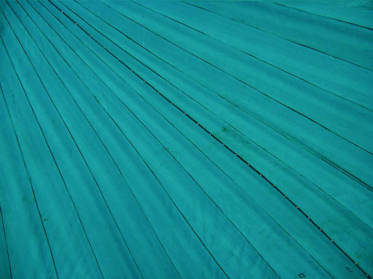 Close-up of a beach umbrella canopy with water beading on surface, demonstrating what makes umbrellas waterproof