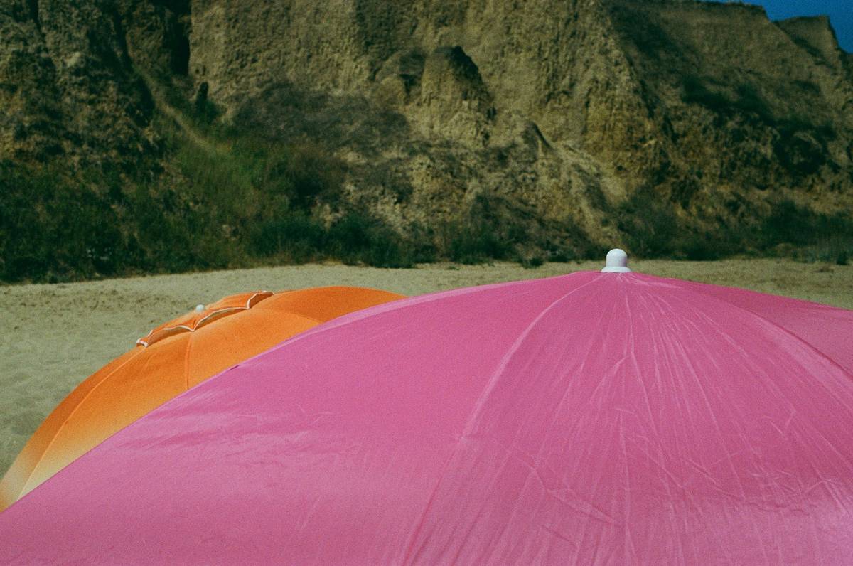 outdoor master beach umbrella anchored securely in sand with family enjoying shade